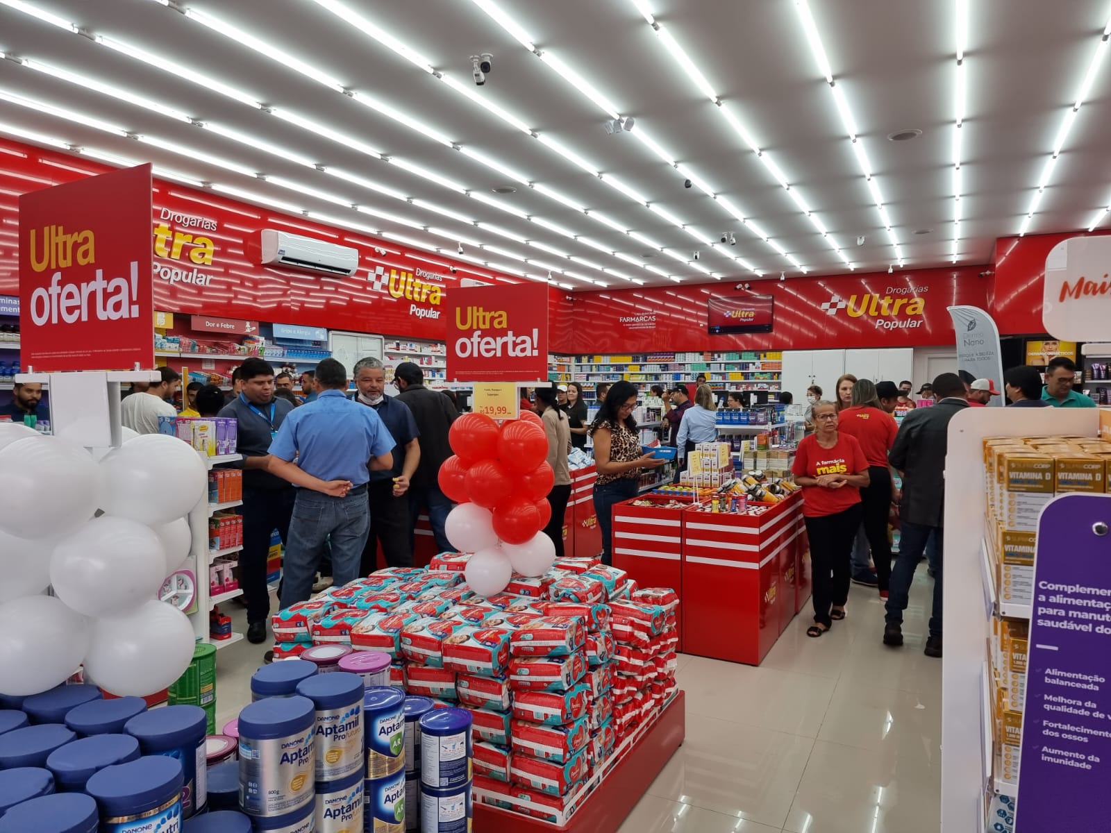 Interior da drogaria com clientes e ofertas